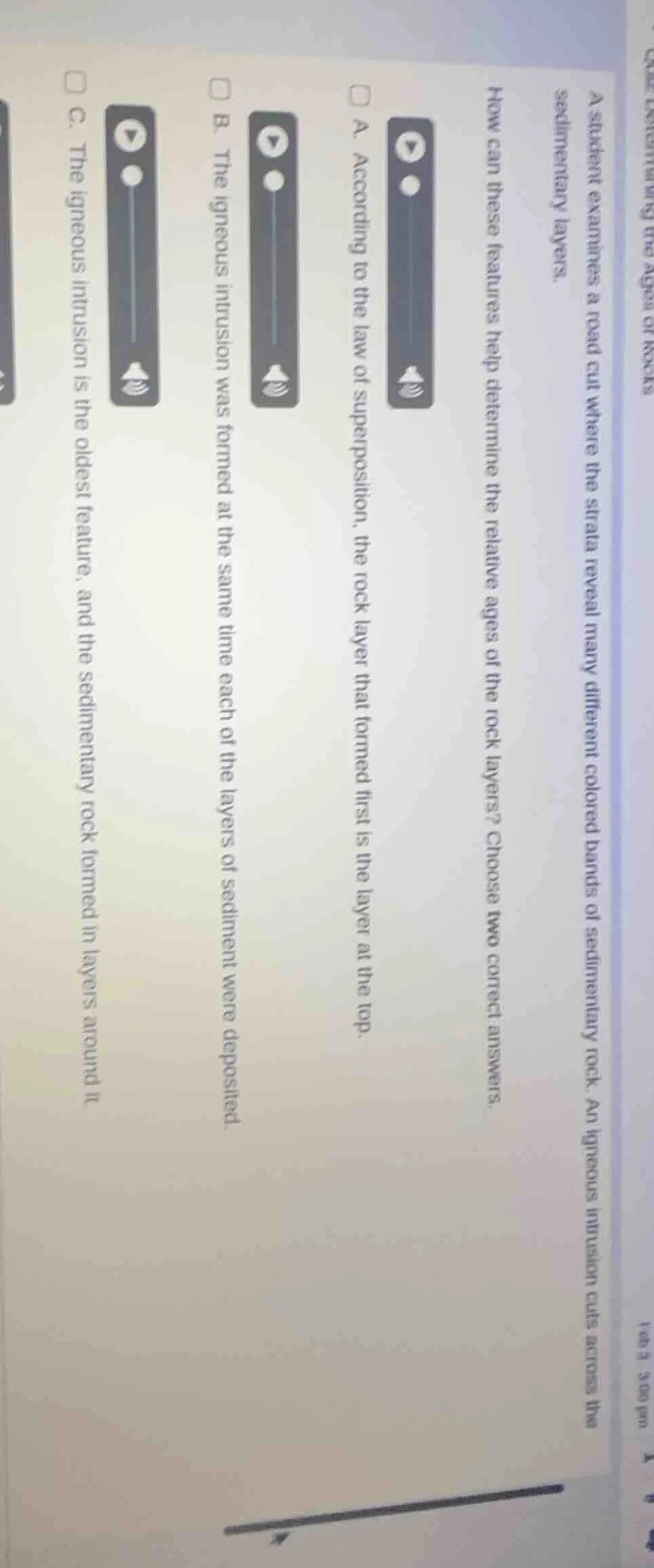 a student examines a road cut where the strata reveal many different co…