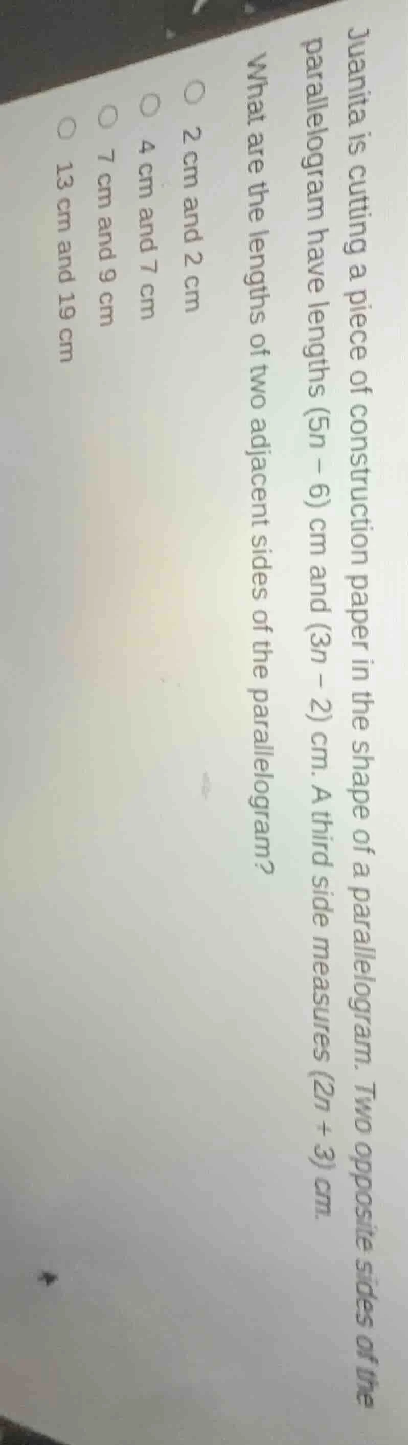 juanita is cutting a piece of construction paper in the shape of a para…